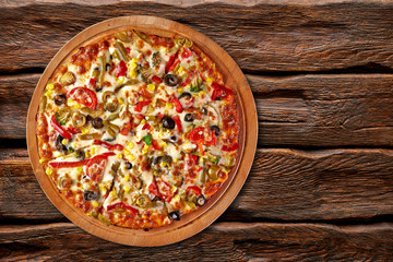 Pizza on wooden table from top view
