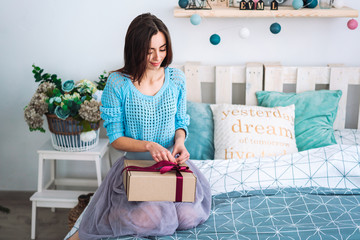 Girl sitting in bed with present box