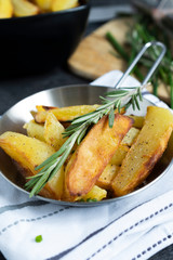 Fried Potatoes with herb Rosemary. Quick and Easy Dinners concept. Crispy Garlic Baked Potato Wedges