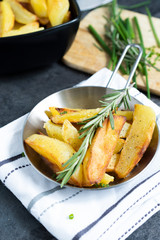 Fried Potatoes with herb Rosemary. Quick and Easy Dinners concept. Crispy Garlic Baked Potato Wedges