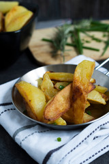 Fried Potatoes with herb Rosemary. Quick and Easy Dinners concept. Crispy Garlic Baked Potato Wedges