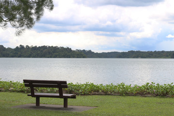 Fototapeta na wymiar empty chair on green grass next to the river.