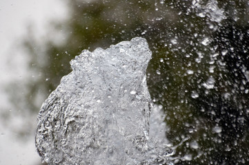 Abstract background of a jet of water in a city fountain water drops fly down, to the side, water splashes