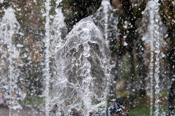 Many water streams, water splashes and drops in the fountain. Abstract background of water trickles and drops.