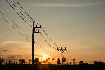 Fototapeta na wymiar an old Power pole with line on Silhouette environment, High level of noise. sun rise or sun set time