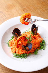 risotto with shrimps and mussels, seafood platter with mussels and shrimps. shrimp on a fork.