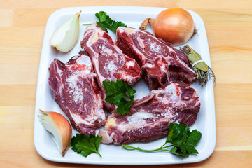 Pieces of fresh lamb on the plate . Delicious fat-tailed lamb with onion on the plate . Meat to be grilled.