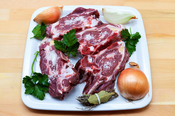 Pieces of fresh lamb on the plate . Delicious fat-tailed lamb with onion on the plate . Meat to be grilled.