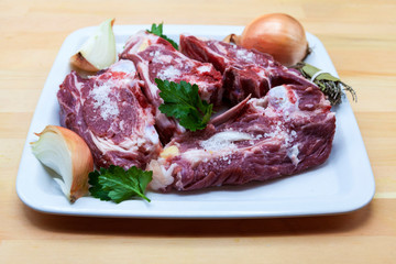 Pieces of fresh lamb on the plate . Delicious fat-tailed lamb with onion on the plate . Meat to be grilled.