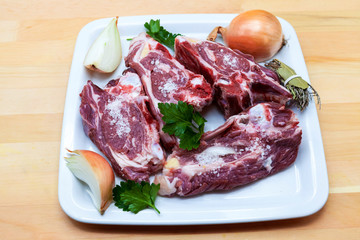 Pieces of fresh lamb on the plate . Delicious fat-tailed lamb with onion on the plate . Meat to be grilled.