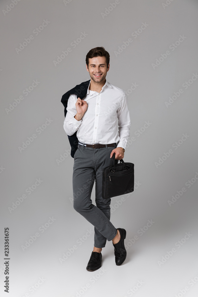 Canvas Prints Full length image of office man 30s walking with bag in hand and holding jacket over his shoulder, isolated over gray background