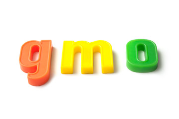 closeup of colorful plastic letters on white background - gmo