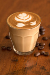 Coffee piccolo latte on wooden desk in coffe's shop