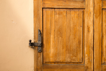 Old rusty hinge on wooden door. Background with copy space