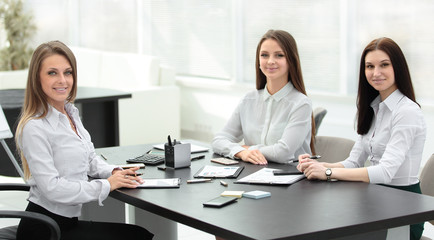Fototapeta premium three young employees sitting behind a Desk