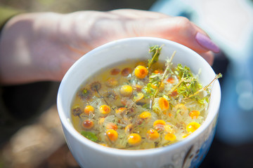 Cup of chamomile tea in hand 