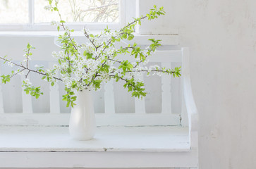 spring flowers in vase on wooden bench