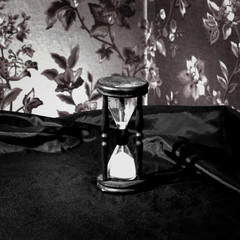 closeup.hourglass with white sand on a wooden table