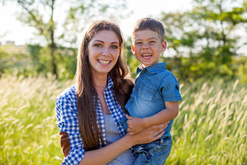 Fototapeta premium Portrait of a mother with a young son for a walk in the Woods