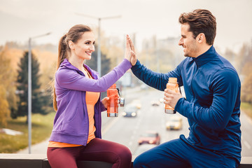 Frau und Mann geben sich Hi-Five nach dem Sport in der Stadt