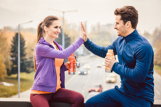 Frau und Mann geben sich Hi-Five nach dem Sport in der Stadt