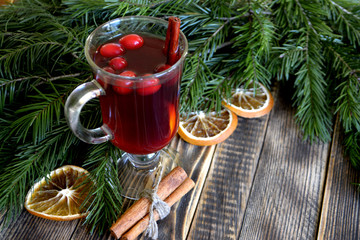 Christmas mulled wine with cranberries in glass Winter warming drink with spices decorated with fir branches cinnamon dried oranges
