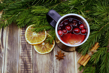 Christmas mulled wine with cranberries in metal mug. Winter warming drink with spices. Decorated...
