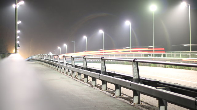 Ponte illuminato dai lampioni di notte con le luci delle automobili in movimento