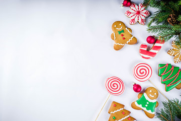Various traditional colorful sugar glazed christmas gingerbread cookies, on white background top view copy space banner with xmas decorations