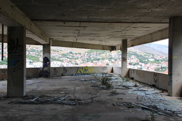 Interior of destroyed building with city in background