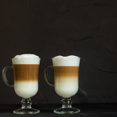 Latte - coffee with milk in a transparent cup on the table. Top view.