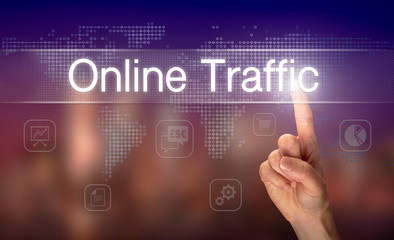 A hand selecting a Online Traffic business concept on a clear screen with a colorful blurred background.