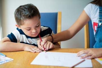 Girl helping her brother to draw