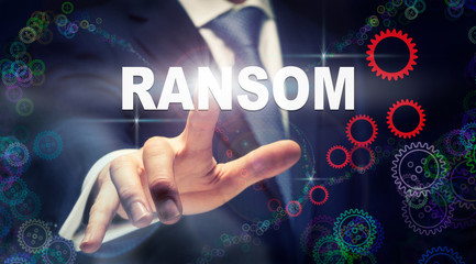 A businessman pressing a Ransom business concept on a graphical display of cogs
