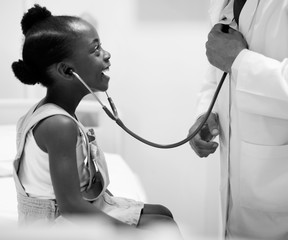 Friendly pediatrician entertaining his little patient