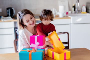 Mother and son holding a gift box for Christmas. At home