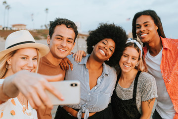 Group of diverse friends taking a selfie at the beach
