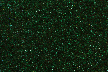 Dark green sparkling background from small sequins, closeup. Brilliant backdrop.