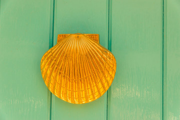 Door with brass knocker in the shape of a shell,  beautiful entrance to the house