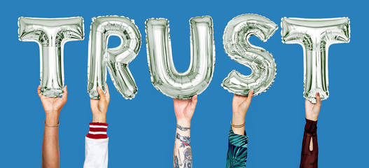 Hands holding trust word in balloon letters