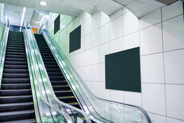 Public escalator with blank billboard on wall © Mumemories