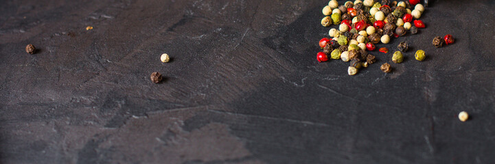pepper peas (multicolored peppers) black, white, pink, green - mix of spices - on a black background. Top view