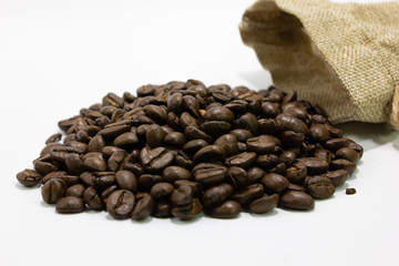 Coffee beans with small bag isolated white background closeup.