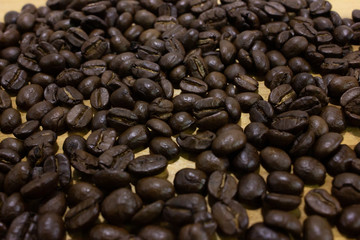 Pile of coffee bean on wooden table closeup.