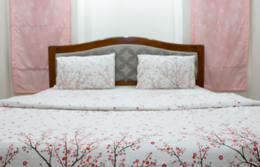 Blurred of white pillow and bedding sheets on natural white wall bedroom background, Messy bed concept