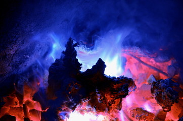 Background consisting of a turquoise flame from burning magnesium on a hot coal anthracite. - obrazy, fototapety, plakaty