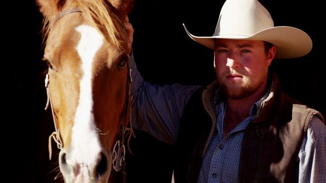 Portrait of a cowboy ranch hand bonding with horse on Dude Ranch Canada