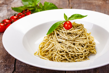 Italian pasta spaghetti with homemade pesto sauce on white plate. Close up