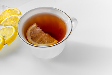 Cup of tea with lemon on white background.