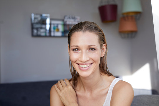 Portrait of laughing blond woman with wet hair at home